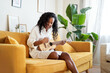 © CarlosBarquero - Young woman singer playing musical instrument sitting on the sofa at home. High quality photo