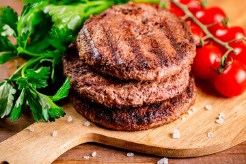 Poster - Burger grill on a cutting board with greens and tomatoes. 