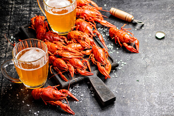 Canvas Print - Boiled crayfish with beer on a cutting board. 