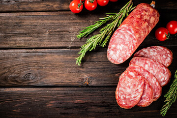 Poster - Pieces of delicious salami sausage with rosemary and tomatoes. 