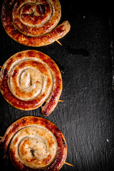 Poster - Round grilled sausages on a black background.