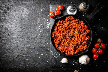 Poster - Bolognese sauce on a stone board with spices, garlic and tomatoes. 