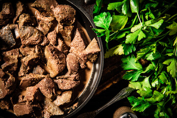 Canvas Print - Homemade liver in a frying pan with parsley. 