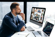 © Kateryna - Thoughtful busy clever caucasian business man, seo, sits at a desk in office, talking on a video conference with his multiracial partners, pensively listens information, thinking over future ideas