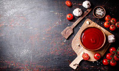 Poster - Tomato sauce on a wooden cutting board with garlic and spices.