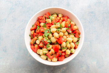 Wall Mural - Healthy food chickpeas salad add tomato coriander in white bowl on blue wood background.