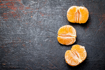 Poster - Peeled tangerines. Against a dark background.