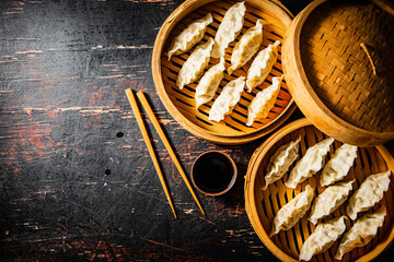 Canvas Print - Ready made dumplings gyoza in a steamer with soy sauce. 