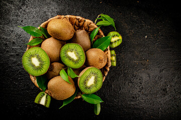 Wall Mural - Fresh kiwi with leaves in a basket. 