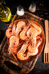 Sticker - Boiled shrimp in a plate on a cutting board with spices. 