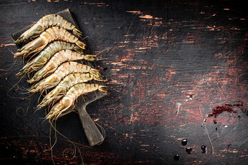 Poster - Raw shrimp on a wooden cutting board. 