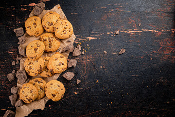 Sticker - Cookies with pieces of milk chocolate on the table. 