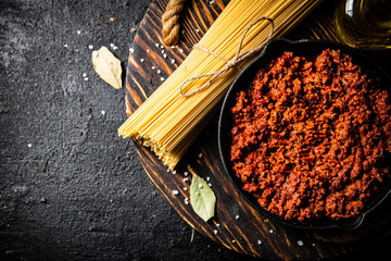 Wall Mural - Bolognese sauce with spaghetti dry on a wooden tray. 