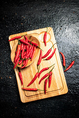 Canvas Print - Pods of hot chili peppers on a cutting board.