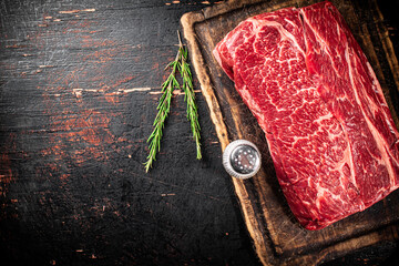 Poster - A piece of fresh raw beef on a cutting board. 