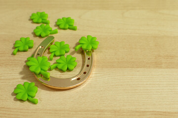 Old horse shoe,with clover leaf, on wooden background