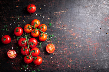 Wall Mural - Tomatoes on a branch with pieces of greens and spices. 