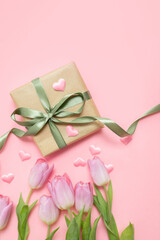 Wall Mural - festive layout with tulips, hearts and a gift with green ribbons on a pastel pink background. copy space. top view. flat lay. concept of mother's day, valentines day, eighth of march