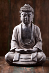 Wall Mural - Meditating Buddha Statue on dark wooden background. 