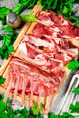 Poster - Raw rack of lamb on a wooden cutting board with parsley. 