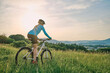 canvas print picture - Cyclist Woman riding bike in helmets go in sports outdoors on sunny day a mountain in the forest. Silhouette female at sunset. Fresh air. Health care, authenticity, sense of balance and calmness.
