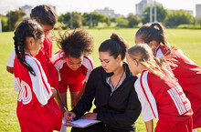 Planning, Sports Or Coach With Children For Soccer Strategy, Training Or Health Goals In Canada. Team Building, Teamwork And Woman Coaching Group Of Girls On Football Field For Game, Match Or Workout