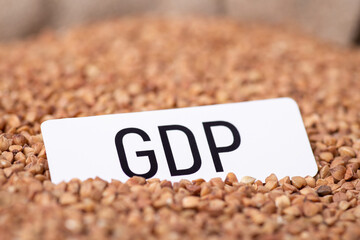 Canvas Print - Paper with inscription GDP on buckwheat grain. Economical aspect of growing grain concept, effect on financial system of the country