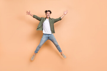 Poster - Full body length size photo of youngster carefree jumper arms star symbol enjoy traveling flying overjoyed isolated on beige color background