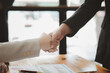 © PHOTO4U - Business investor group holding hands, Two businessmen are agreeing on business together and shaking hands after a successful negotiation. Handshaking is a Western greeting or congratulation.
