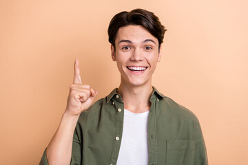 Poster - Photo of cheerful smart person beaming smile point finger brilliant excellent idea isolated on beige color background