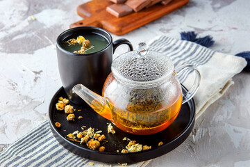 Hot tea in glass cup with steam and lemon .tea leaves and mint herb on wood background , cup of Asian herbal tea