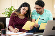 © WESTOCK - Serious young indian couple calculating expenses or monthly bills in front of laptop while sitting at home - concept of investment, budget and financial planning