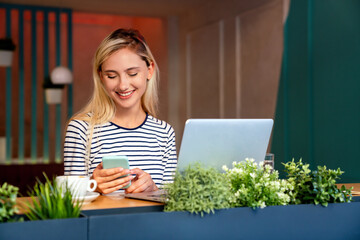 Wall Mural - Portrait of a woman working on laptop in cafe. People business education digital device concept.