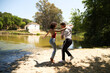 beautiful woman and handsome man latinos dancing bachata are dancing by the river in the forest. The couple do different postures while dancing. Dancing concept and expressions.