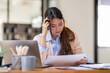 © David - Young business Asian women are stressed while working on laptop, Tired asian businesswoman with headache at office, feeling sick at work copy space in workplace an home office.