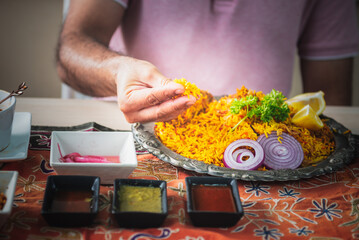 Close-up of Indian man's hand Picking up Indian food, which is to food culture of Indians, to Indian family and food concept.