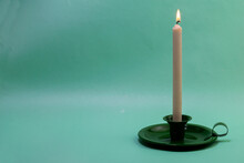 Green Candlestick With A Burning Candle