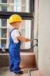 © anatoliy_gleb - Kid welding electrical wire with electric soldering iron. Child electrician in work overalls and safety helmet installing electrical cables and sockets in apartment under renovation.