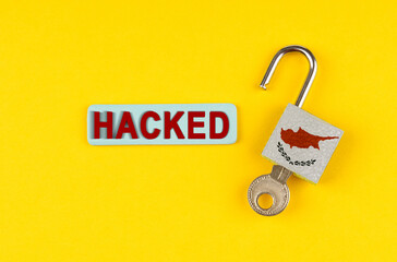 Poster - On the yellow surface is an open lock with a key and a sticker with the inscription - hacked