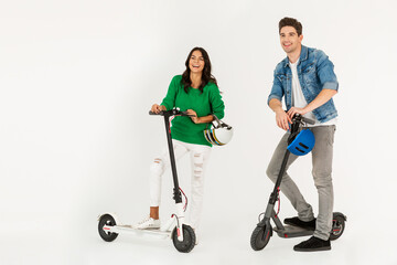 a couple riding on electic kick scooter isolated on white studio background