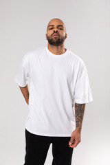 Bald guy african american with a beard in a white blank t-shirt. Mock-up.