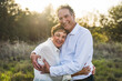 © Cavan Images - Senior couple hugging and smiling outside in backlight