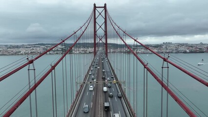 Poster - Traffic on The 25 April bridge (Ponte 25 de Abril) located in Lisbon, Portugal, crossing the Tagus river. Drone. 4k