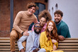 © Roman - Business people in formal suit having fun together spending time in street of city, looking excited, happy men and women of diverse interracial ethnicities sit on bench enjoying leisure. portrait