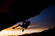 A Young Man Climbs A Boulder Problem During A Sunset Overlooking The Ocean In Santa Barbara, CA.