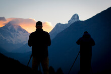 Photographers In Silhouette Photograph The Sunrise Over Ama Dablam In Nepal's Everest Region.