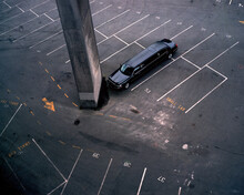 A Black Limousine Is Parked In An Empty Parking Lot.