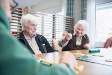 Senior Inhabitants Playing Board Game In Rest Home
