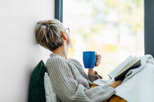 Woman Reading Book And Drinking Coffee