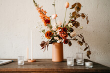 Orange Flowers And Candles On A Rustic Table Indoors